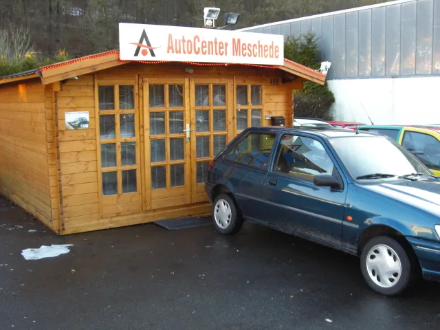 Le premier bureau dans une cabane en bois avec une voiture devant